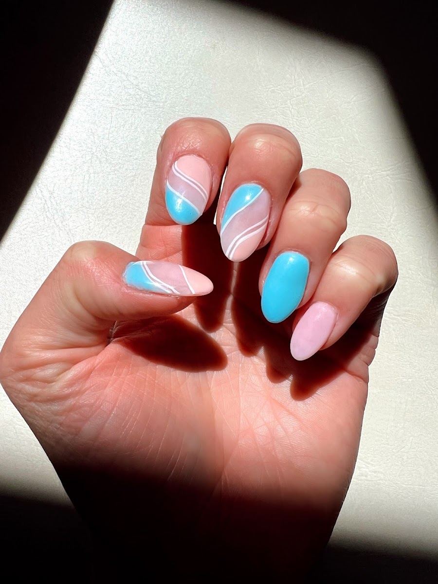 Almond nails in sky blue and pale pink with white swirl lines