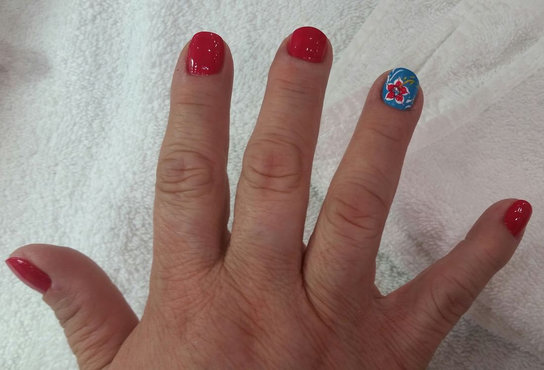 Red polish with a single accent nail with flower art