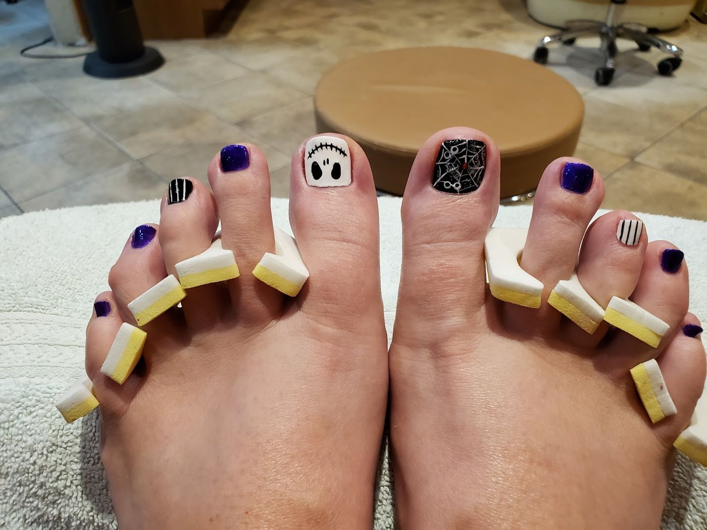 Pedicure with ghost face, spiderweb and deep purple toe art
