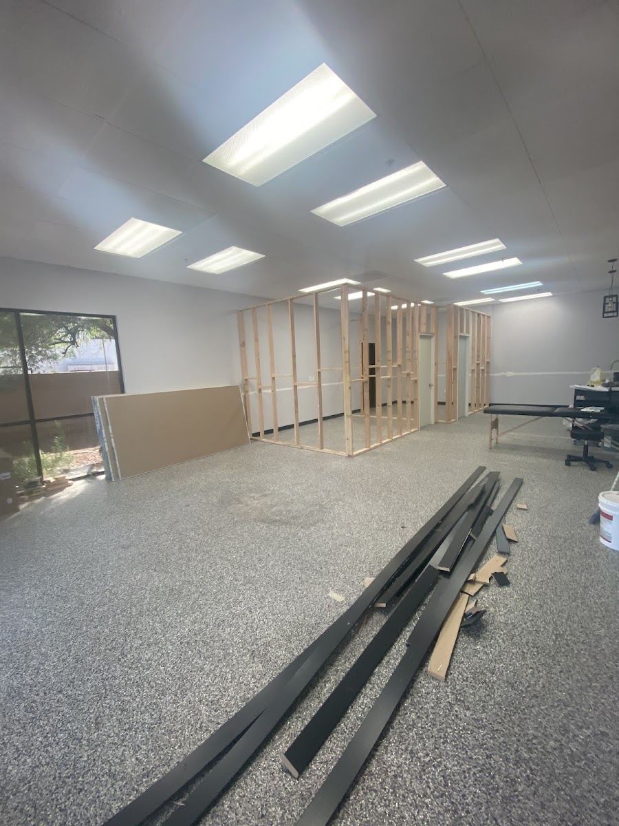 Long room with framed walls going up and trim laid out on the floor