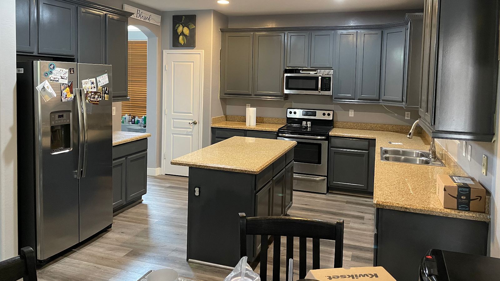 Finished kitchen with dark gray cabinets, a center island and stainless appliances