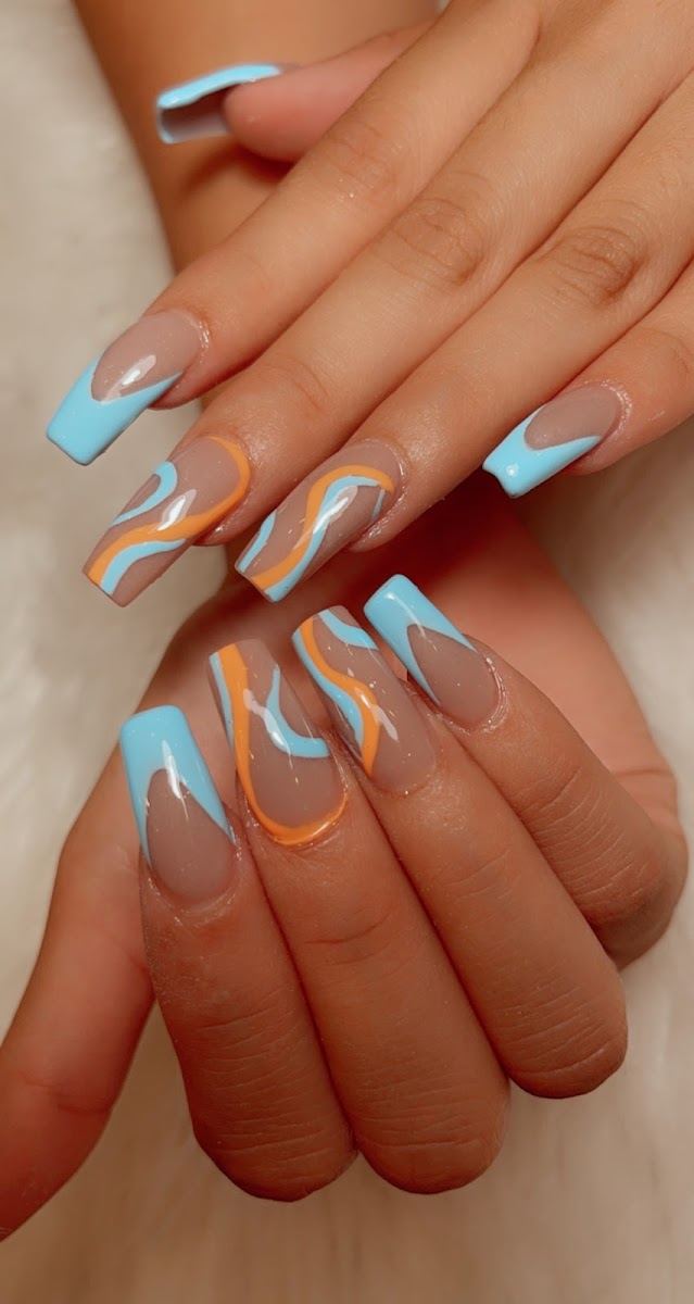 Clear nails with blue French tips and orange swirl art
