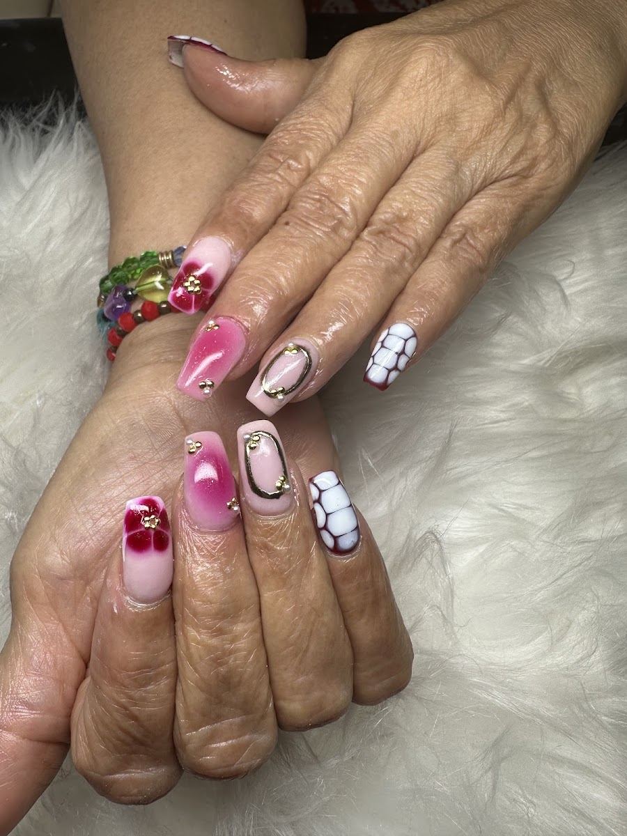 Nail art with pink ombre, a red flower and white accents