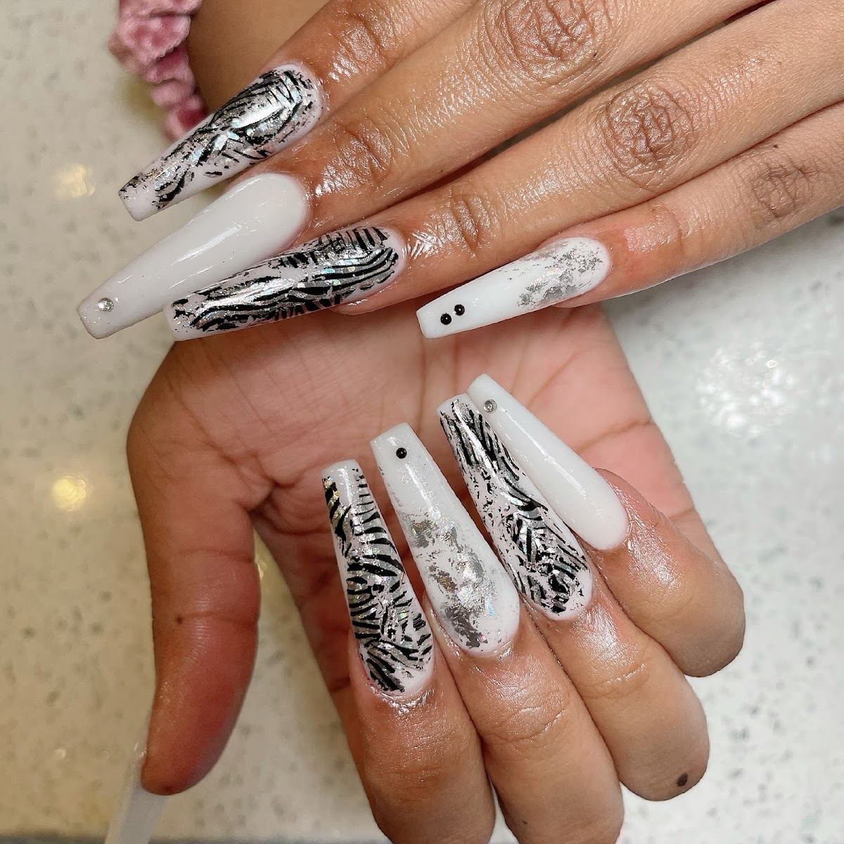 Long coffin nails with black and white zebra art and nude polish