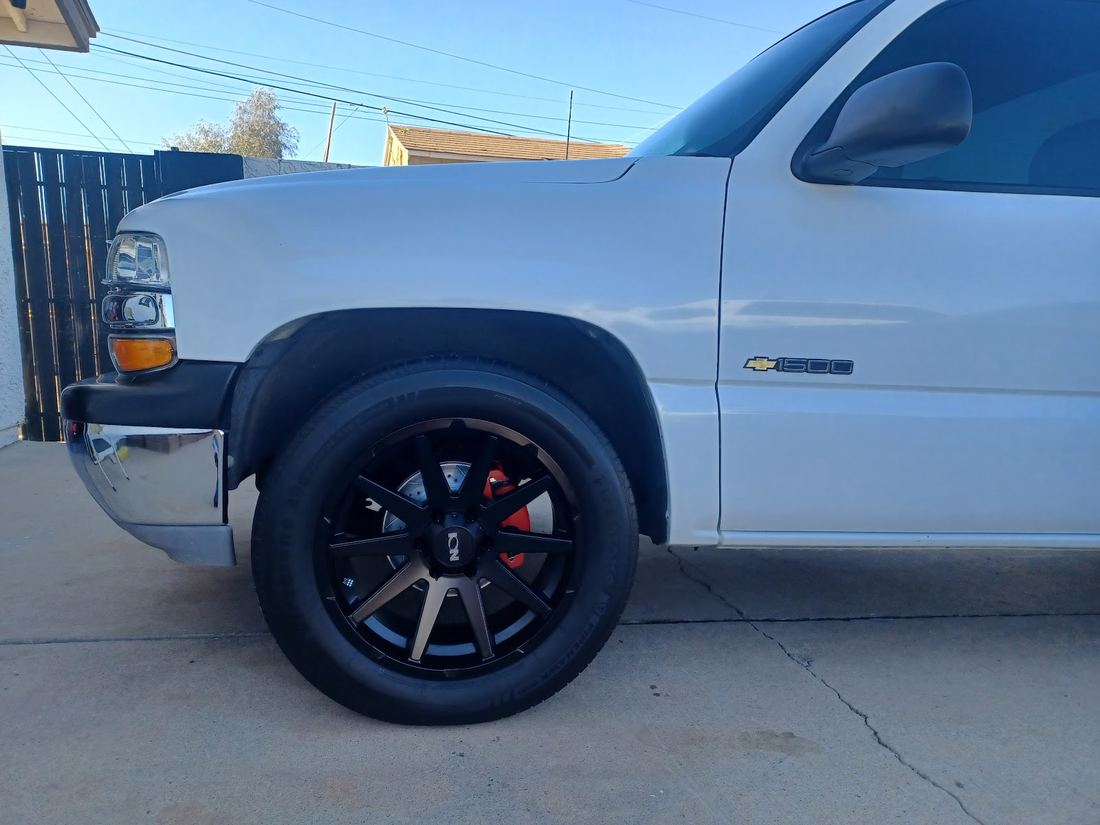 White Chevy truck with black wheels and red brake calipers