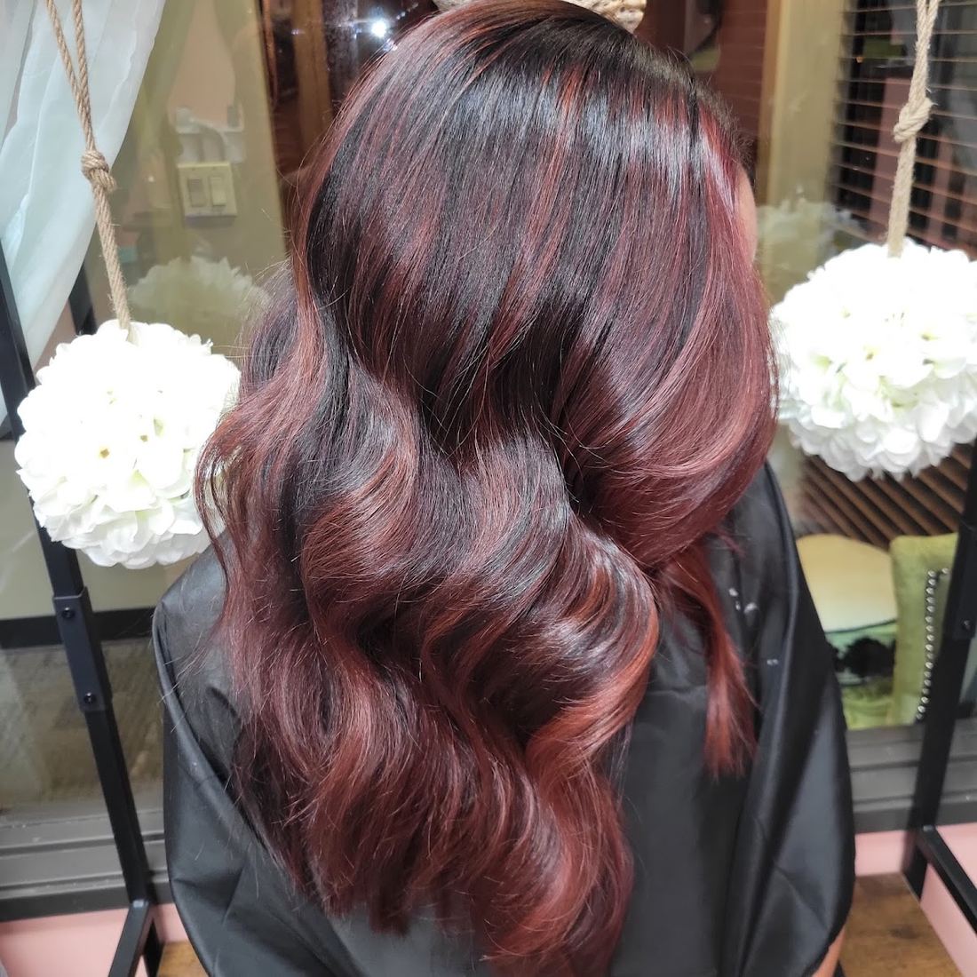Shoulder length dark hair with deep red dimension in soft waves
