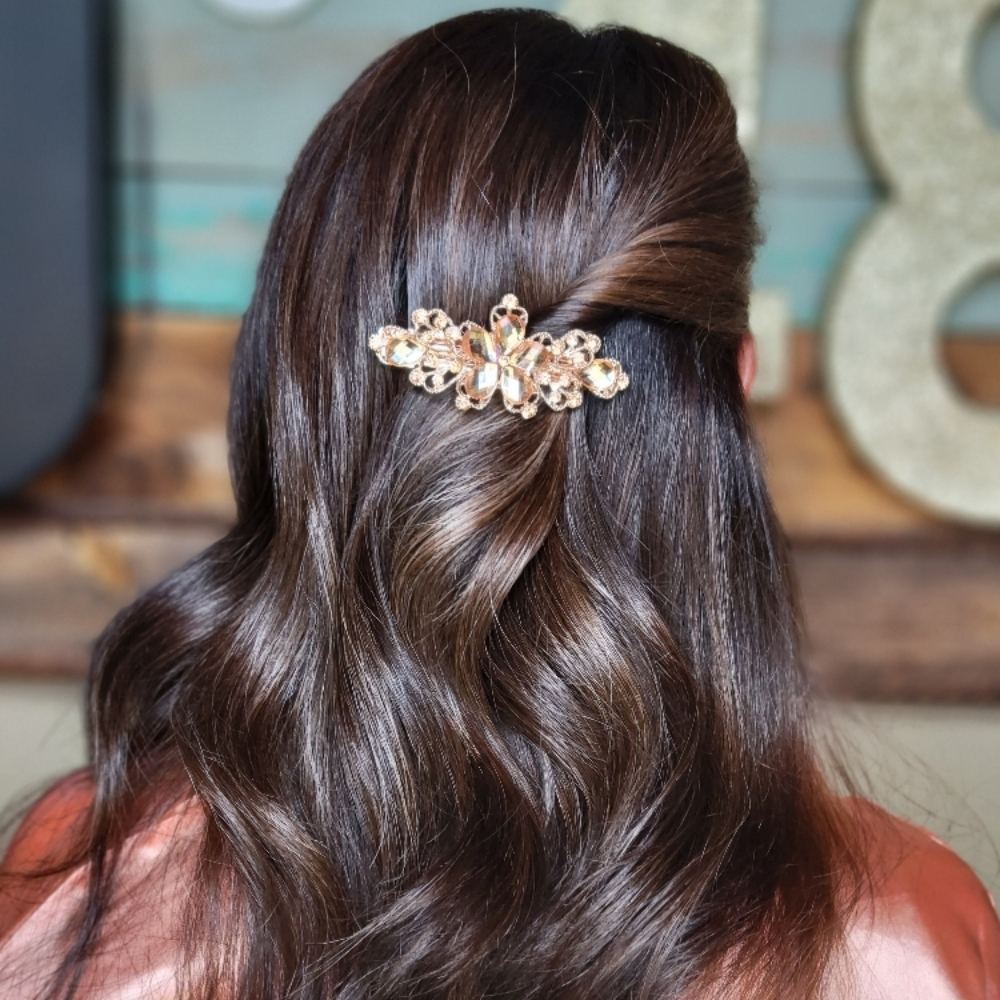 Long brunette waves pinned back with a jeweled clip