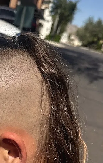 A haircut seen from the side: a skin fade up the side and long hair left at the back