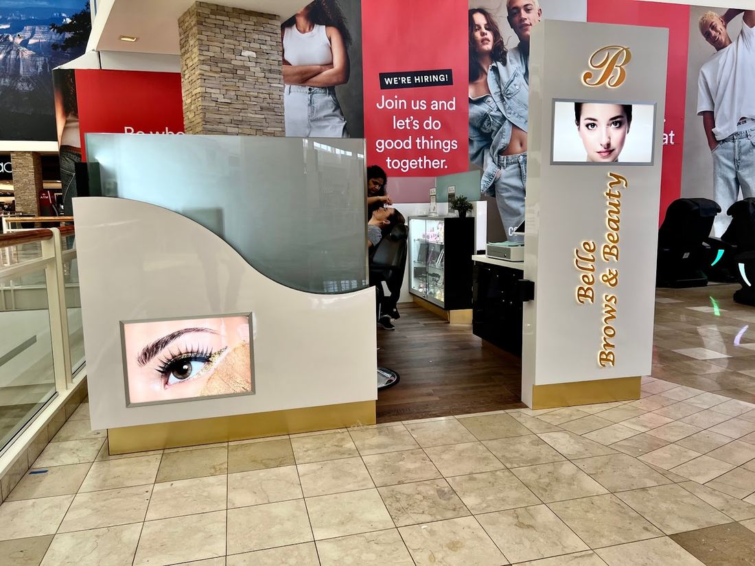 The Belle Brows and Beauty kiosk with its tall gold lettered sign