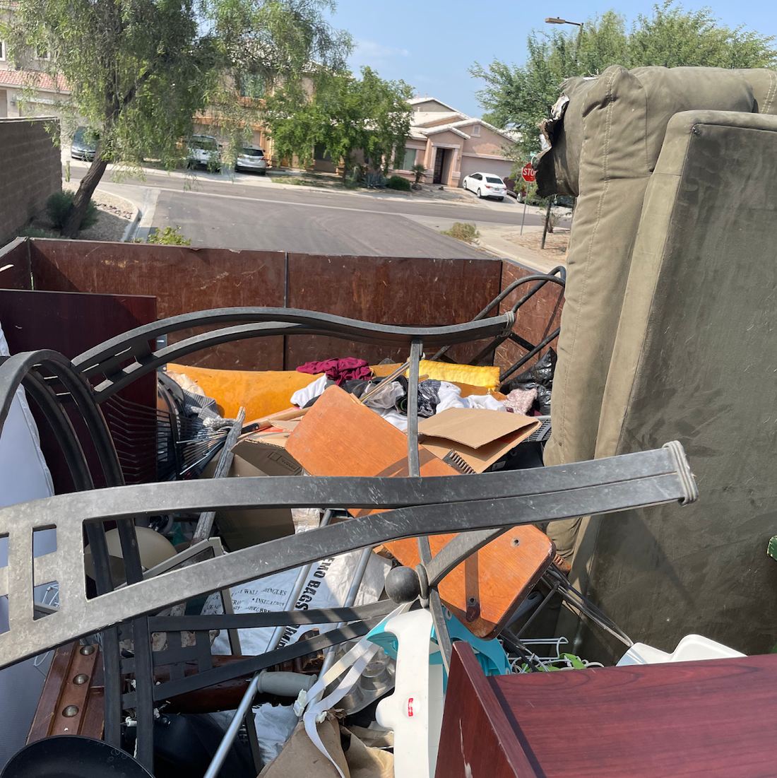 Truck bed packed with a sofa, metal bed frame and household junk