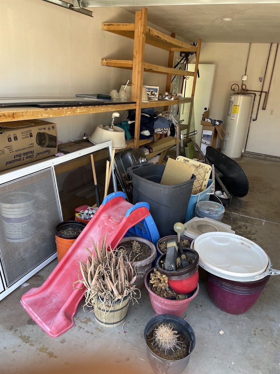 Garage corner full of shelves, pots, a slide and storage bins