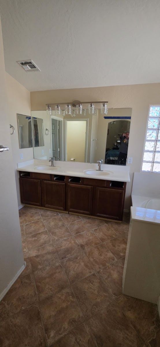 Bathroom with double vanity and tile floor
