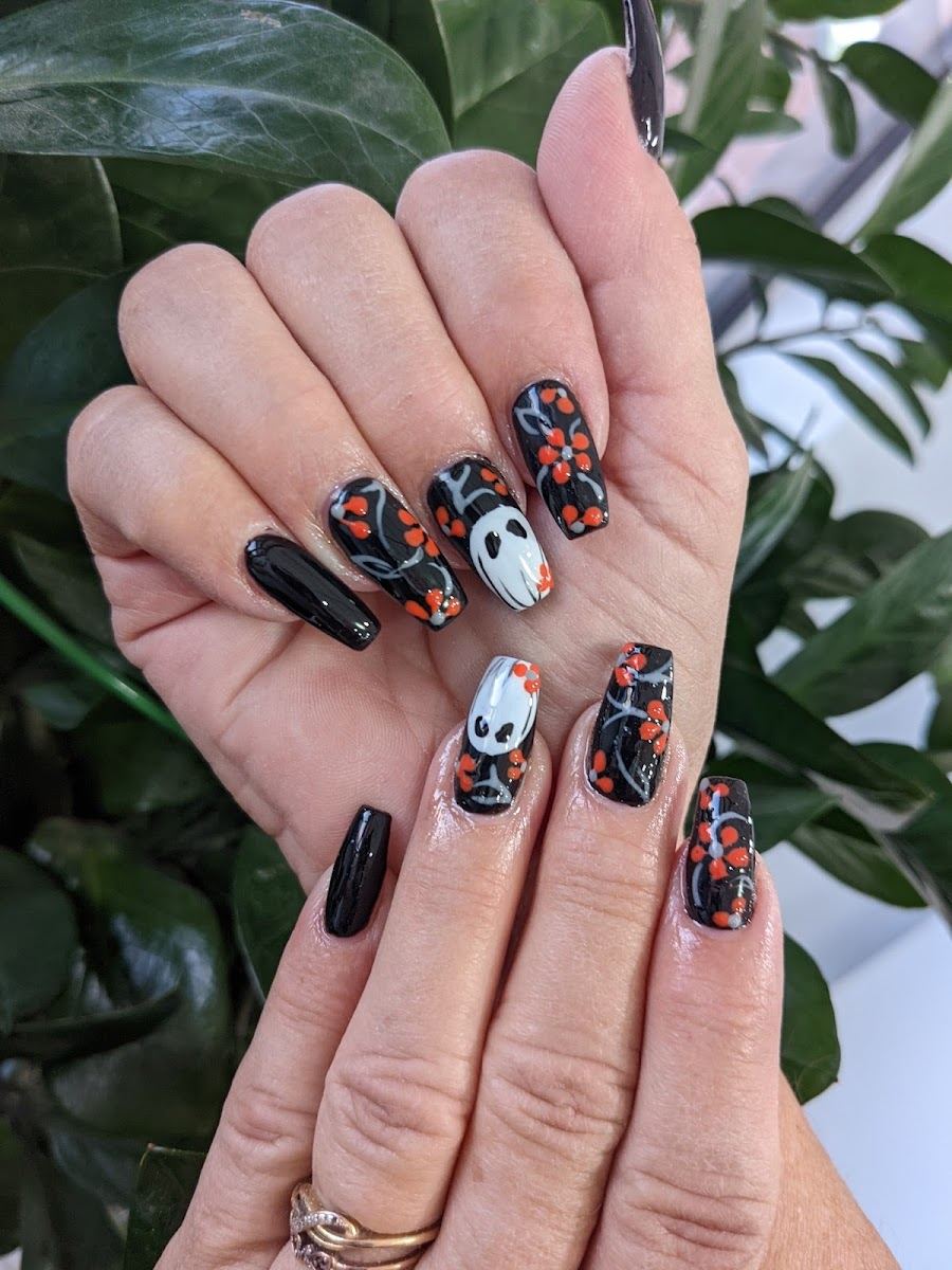 Black nails with red florals and a hand painted character