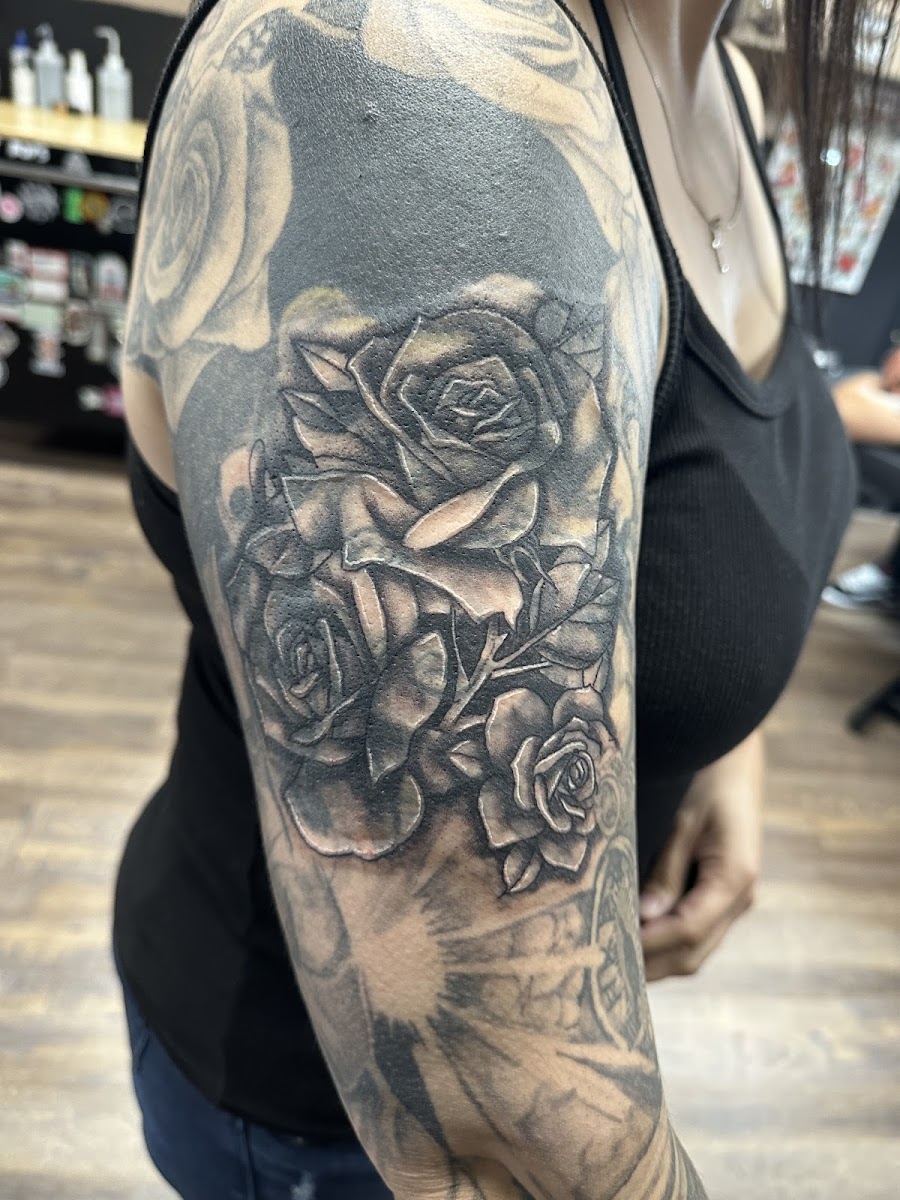 Black and grey rose tattoo on a shoulder and upper arm
