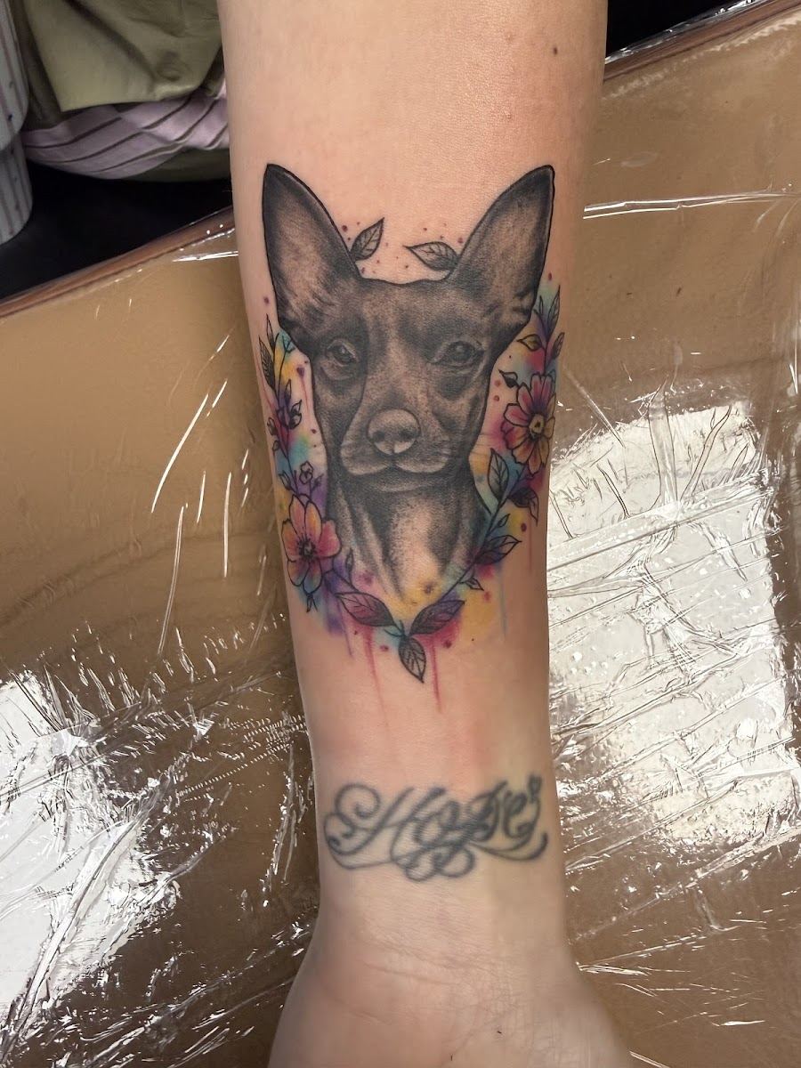 Color pet portrait tattoo of a dog framed in flowers
