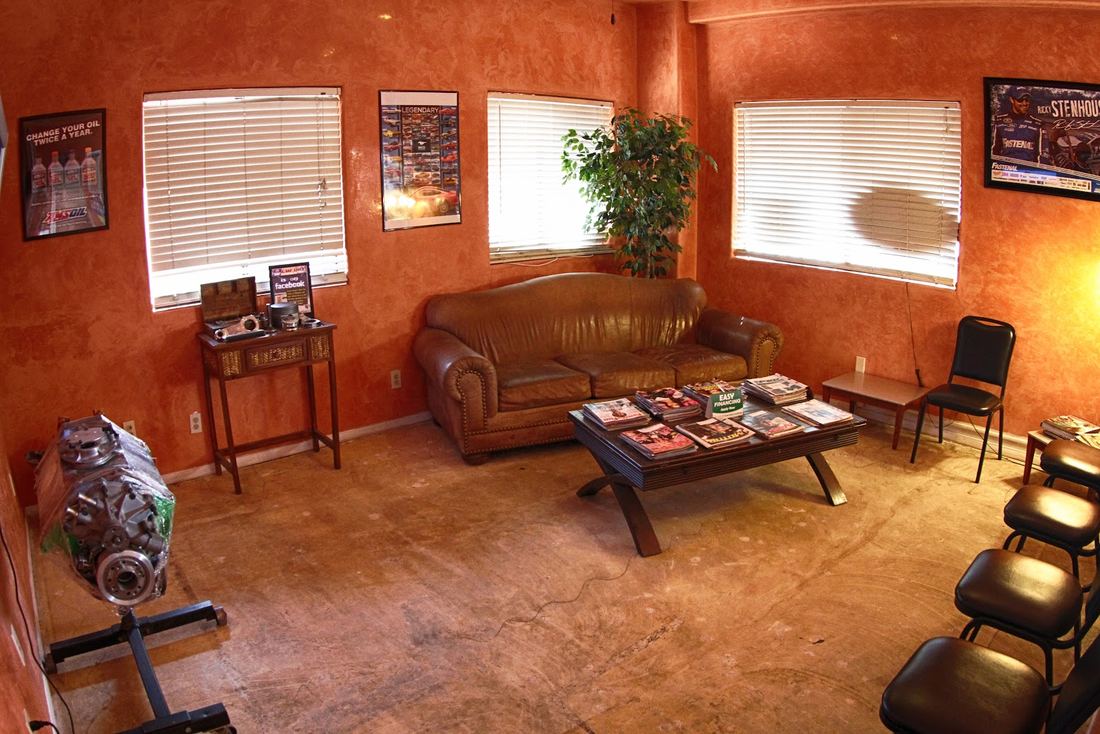 Customer waiting room with leather couch and framed pictures
