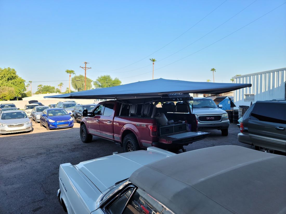 Shaded parking area with customer cars and trucks
