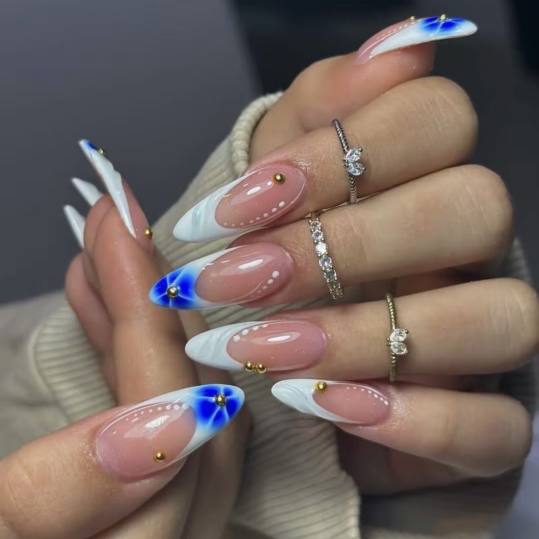 Nude almond nails with a peppermint swirl and a green bow accent