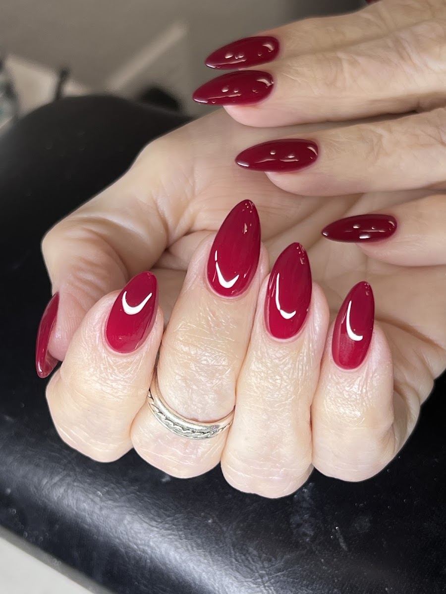 Glossy deep red almond manicure