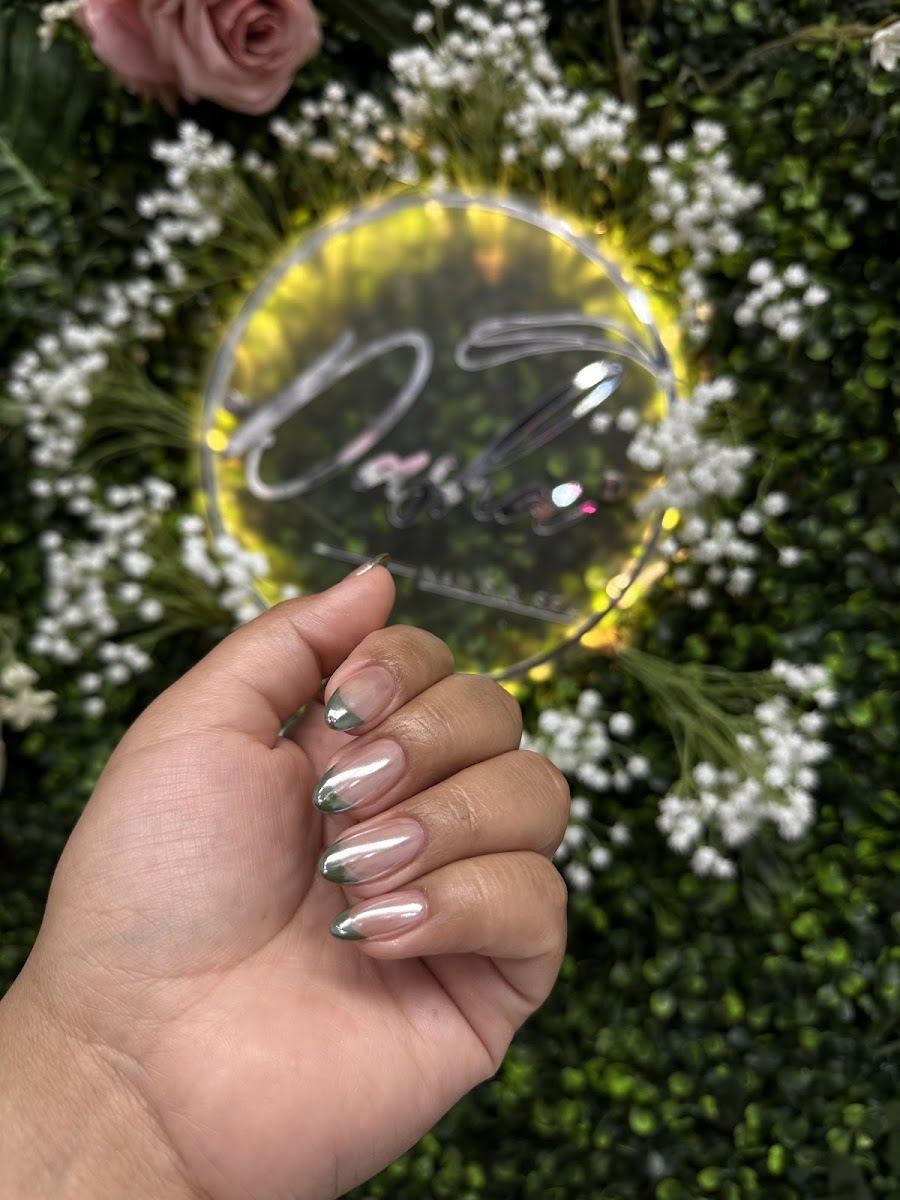 Chrome nails held up in front of a lit floral sign