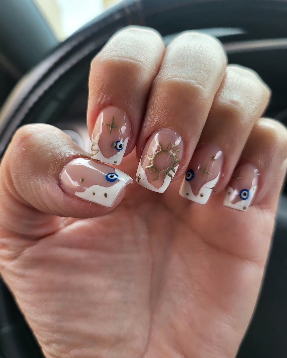 Hand-painted nail art with evil eye and star details