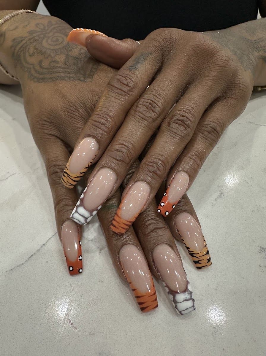 Long nude coffin nails with orange tiger stripe and dotted tips