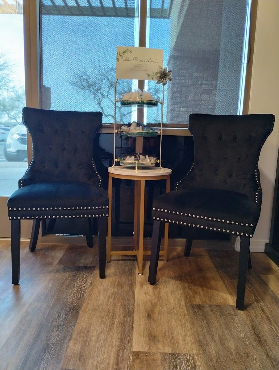 Two tufted black chairs by the window