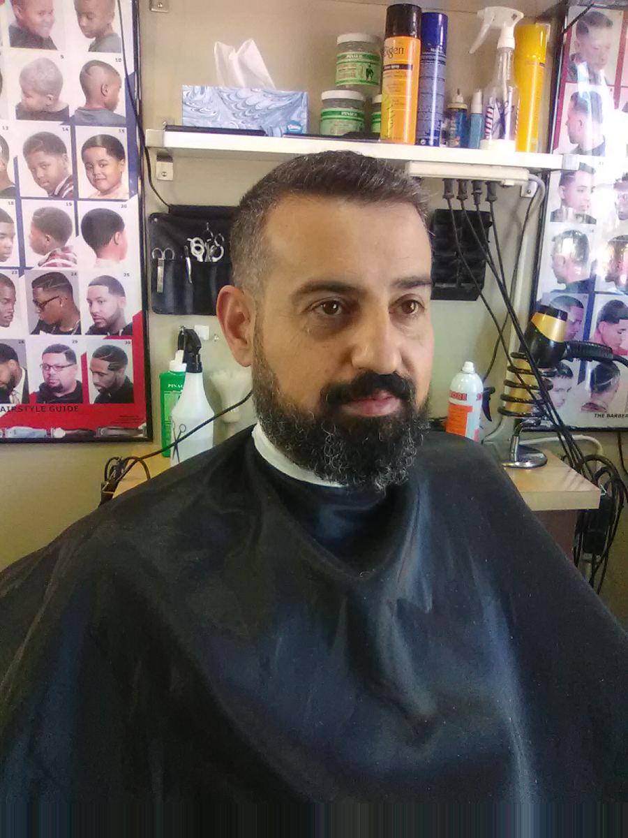 Man with a full beard and short cut in the barber chair