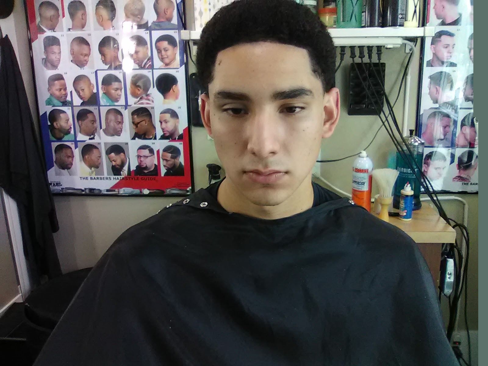 Young man in a barber cape after a fresh cut at Duane's Barber Studio