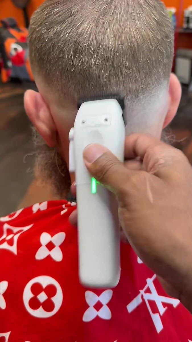 Barber blending a fade on the back of a client's head with clippers