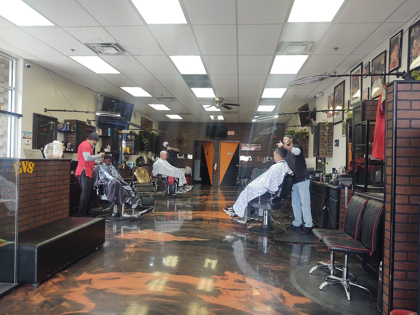 Inside East Valley Styles: a long row of barber chairs with barbers cutting hair