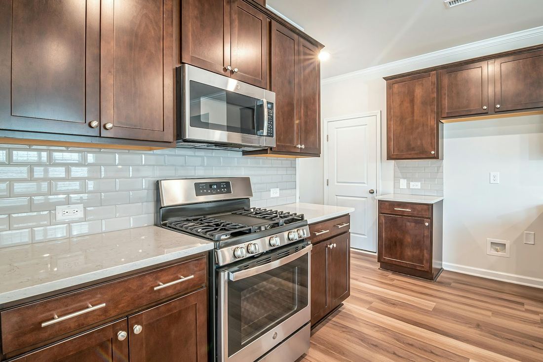 Wood cabinet kitchen with subway tile and stainless range