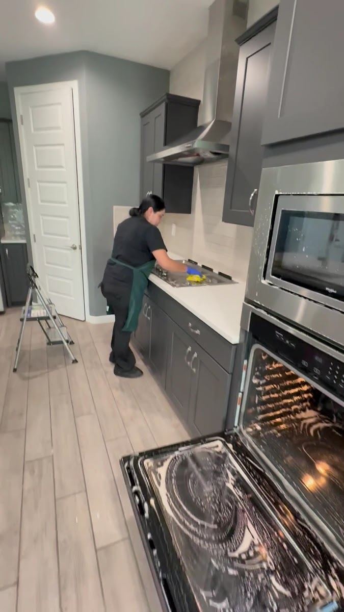 An Eco Shine cleaner wiping down a kitchen counter beside an open oven