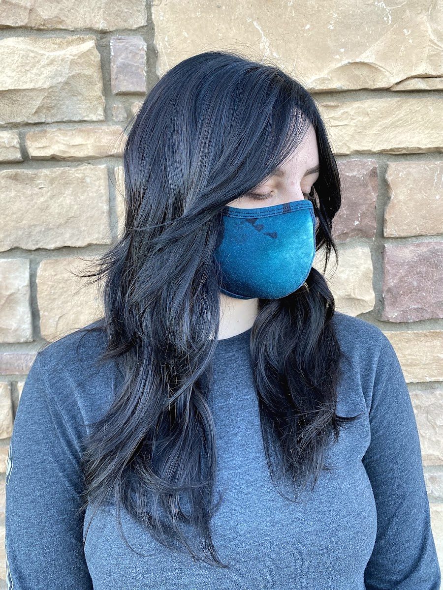 Client in a blue mask with long layered hair in deep blue-black