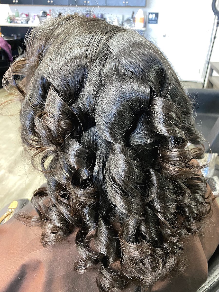Glossy dark hair set in large, bouncy barrel curls
