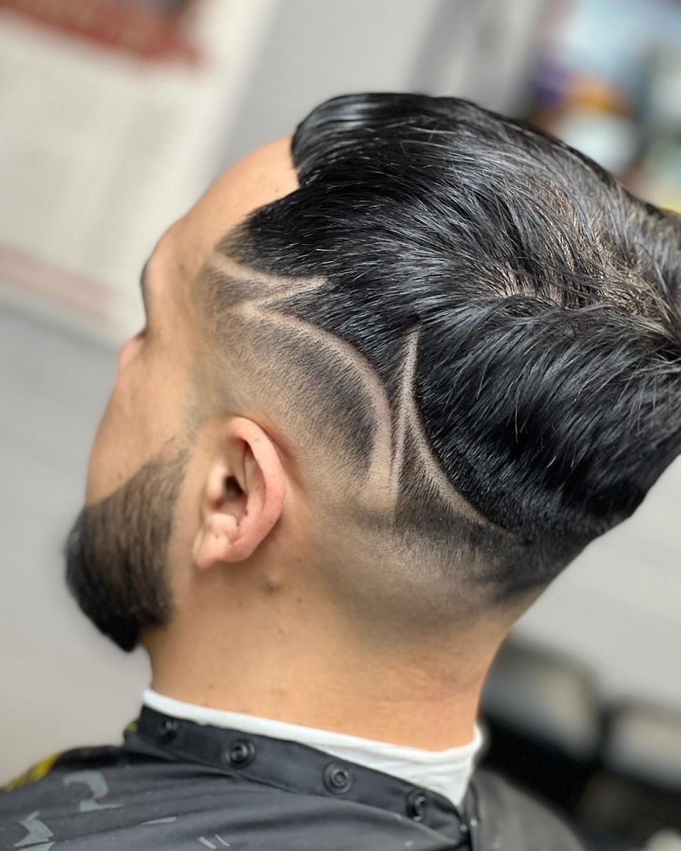 Client with a fade, hair design lines and a shaped beard at El Patrón