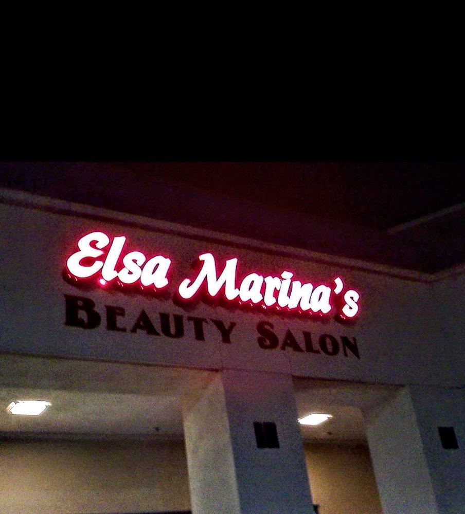 The lit Elsa Marina's Beauty Salon sign at night