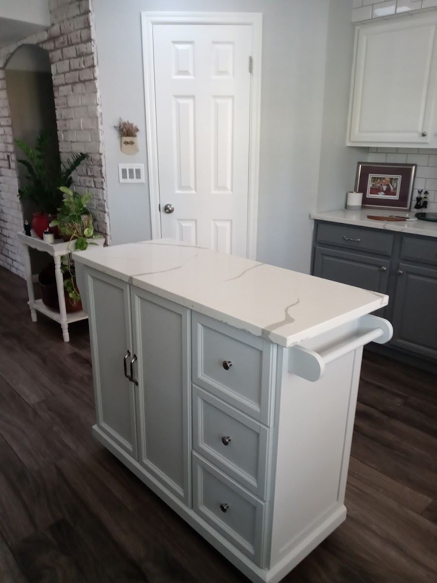 White kitchen island with a stone top and drawers