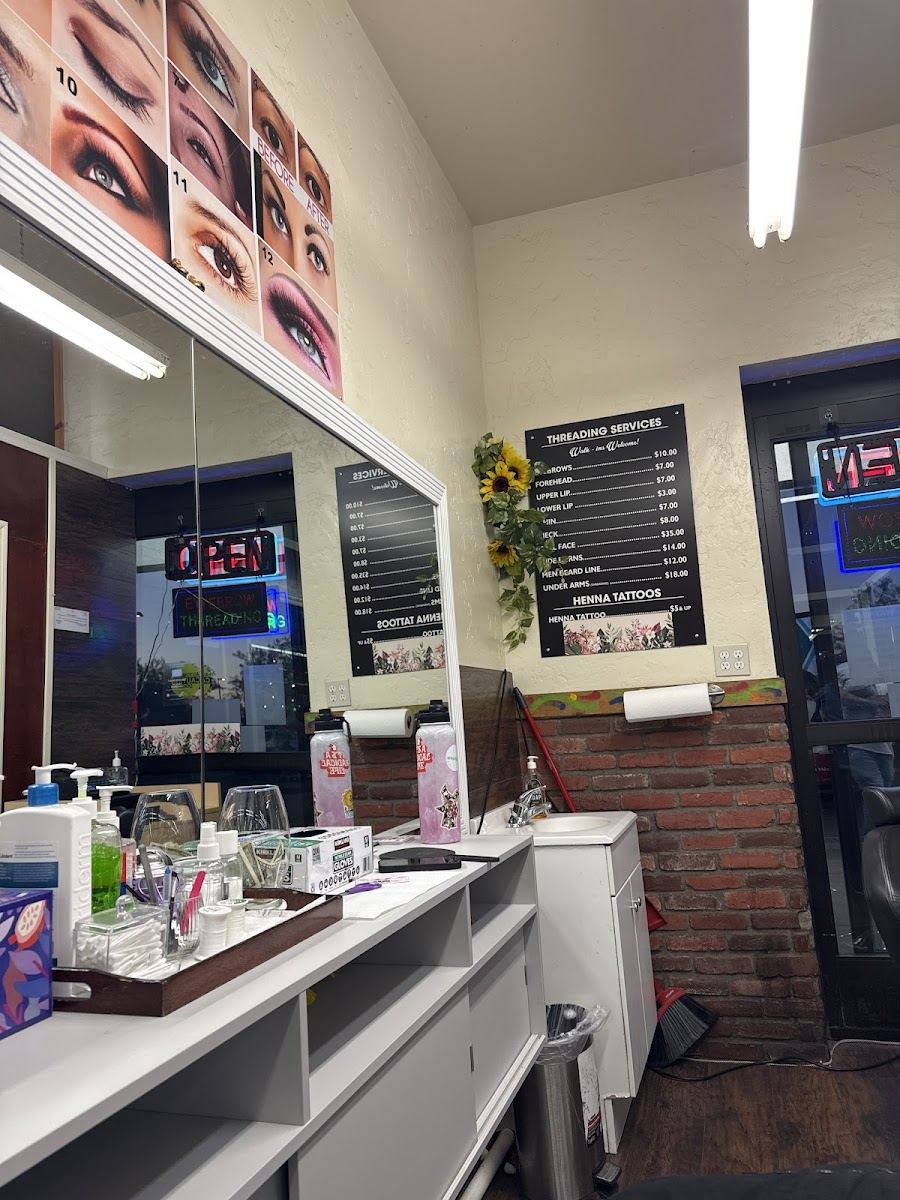 Inside the studio: threading chair, mirror wall, eyebrow photos and the services board