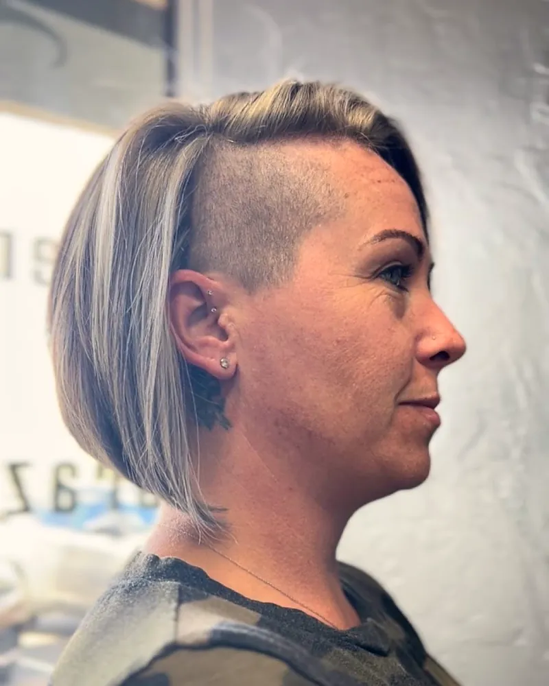 A short ash blonde bob with a shaved undercut at the side, seen in profile