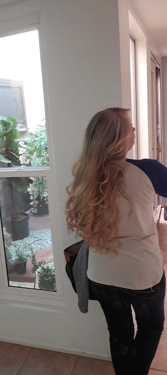 A client from behind with long, wavy light brown hair reaching mid-back