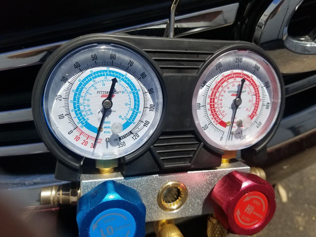 Two pressure gauges, blue and red, hooked up on a job