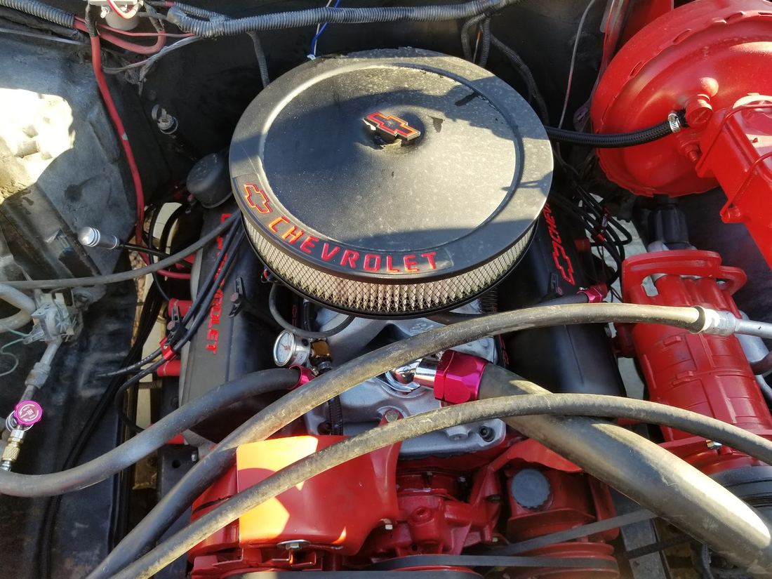 Chrome Chevrolet air cleaner on a red engine bay
