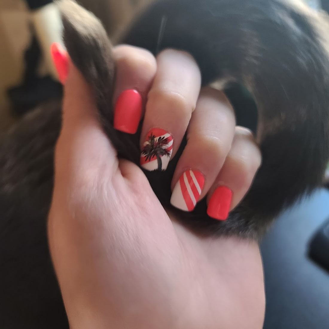 Close up of coral nails with palm tree and stripe accent art
