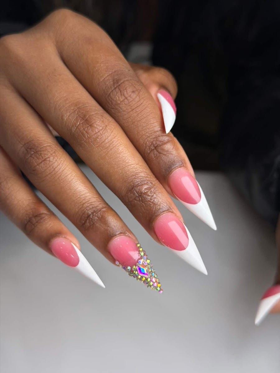 Pink stiletto nails with white French tips and a crystal accent