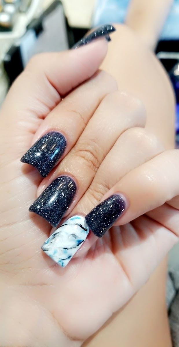 Short square nails in navy glitter with one marble accent nail