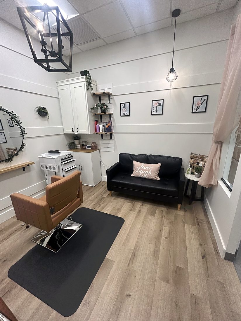 Inside the suite: a cognac salon chair, a black leather sofa, white shiplap walls and a black lantern light