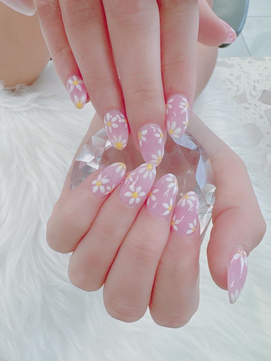 Sheer pink almond nails with tiny white daisies