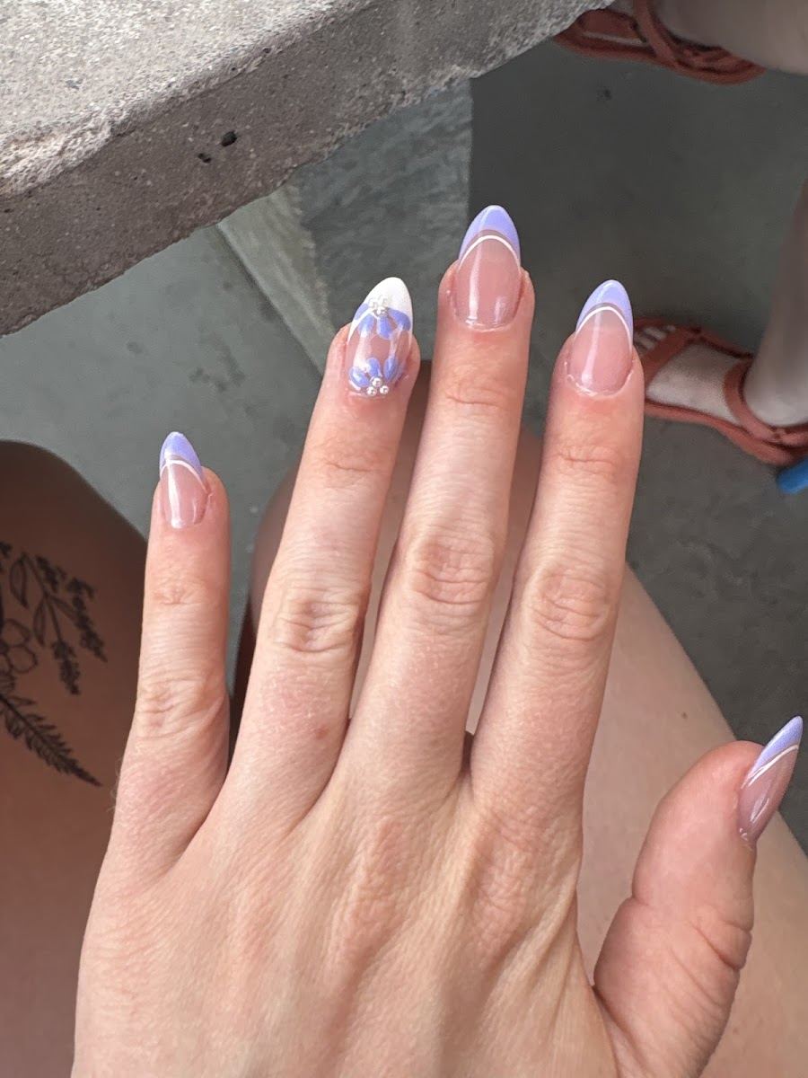 Natural nails with a lilac French tip and small flower accent