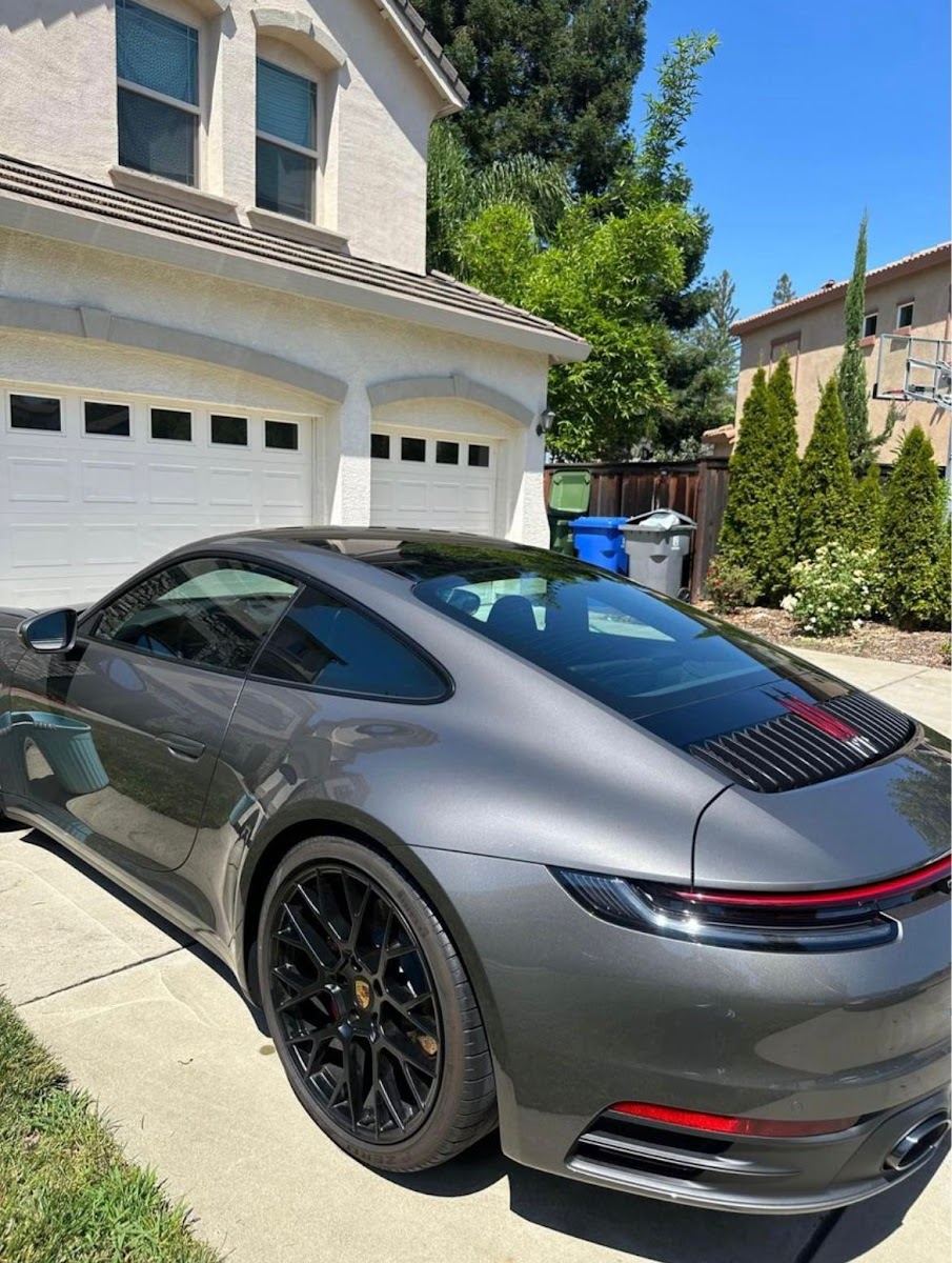 Gray Porsche 911 finished and gleaming in a customer's driveway